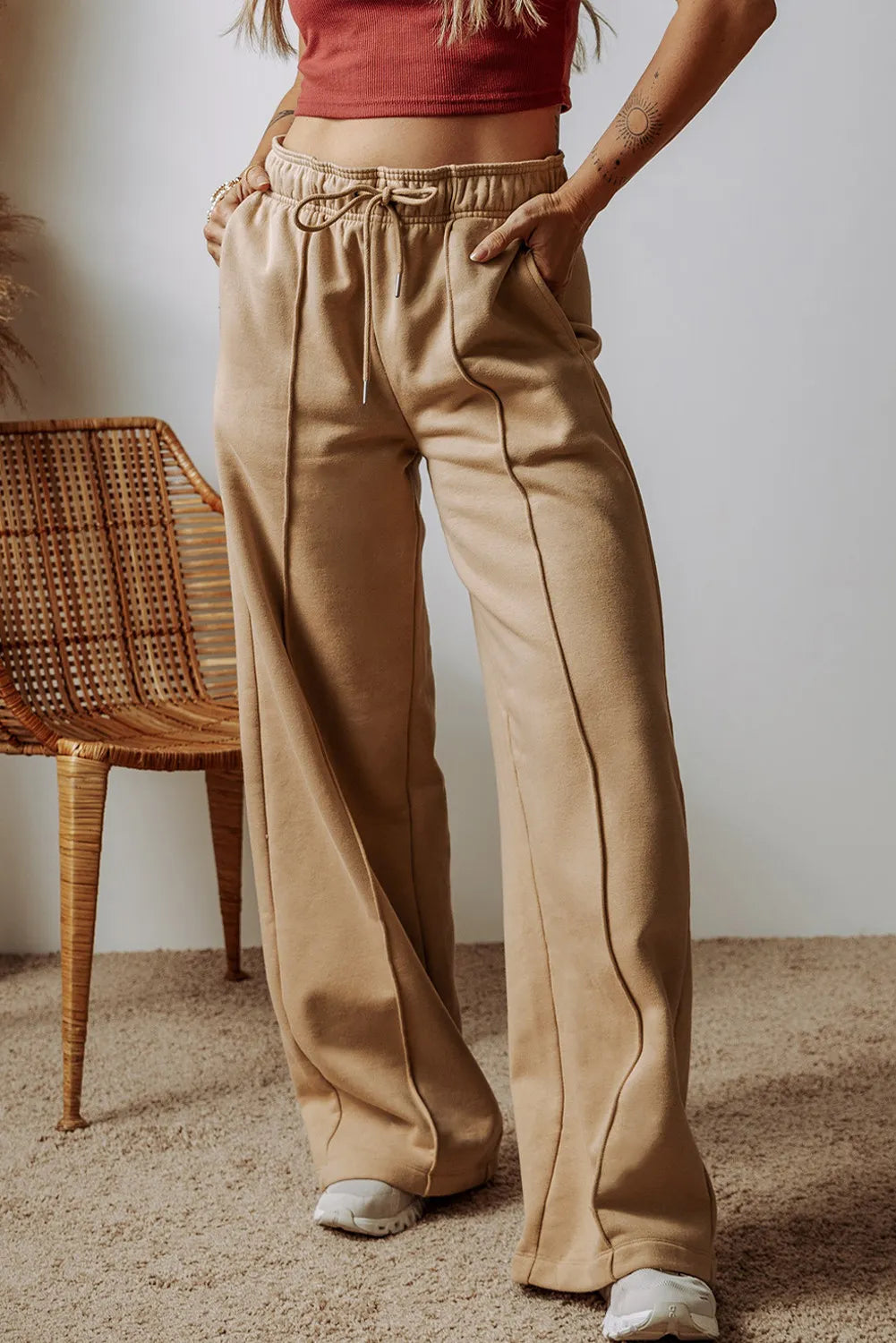 Tan wide-leg drawstring pants with side pockets, relaxed ankle length