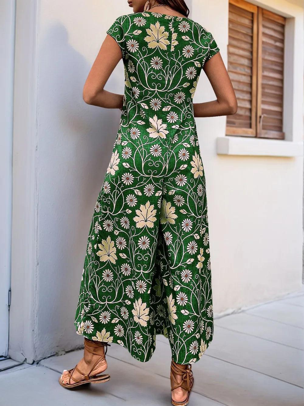 Back view of green printed wide-leg jumpsuit with short sleeves and open neckline