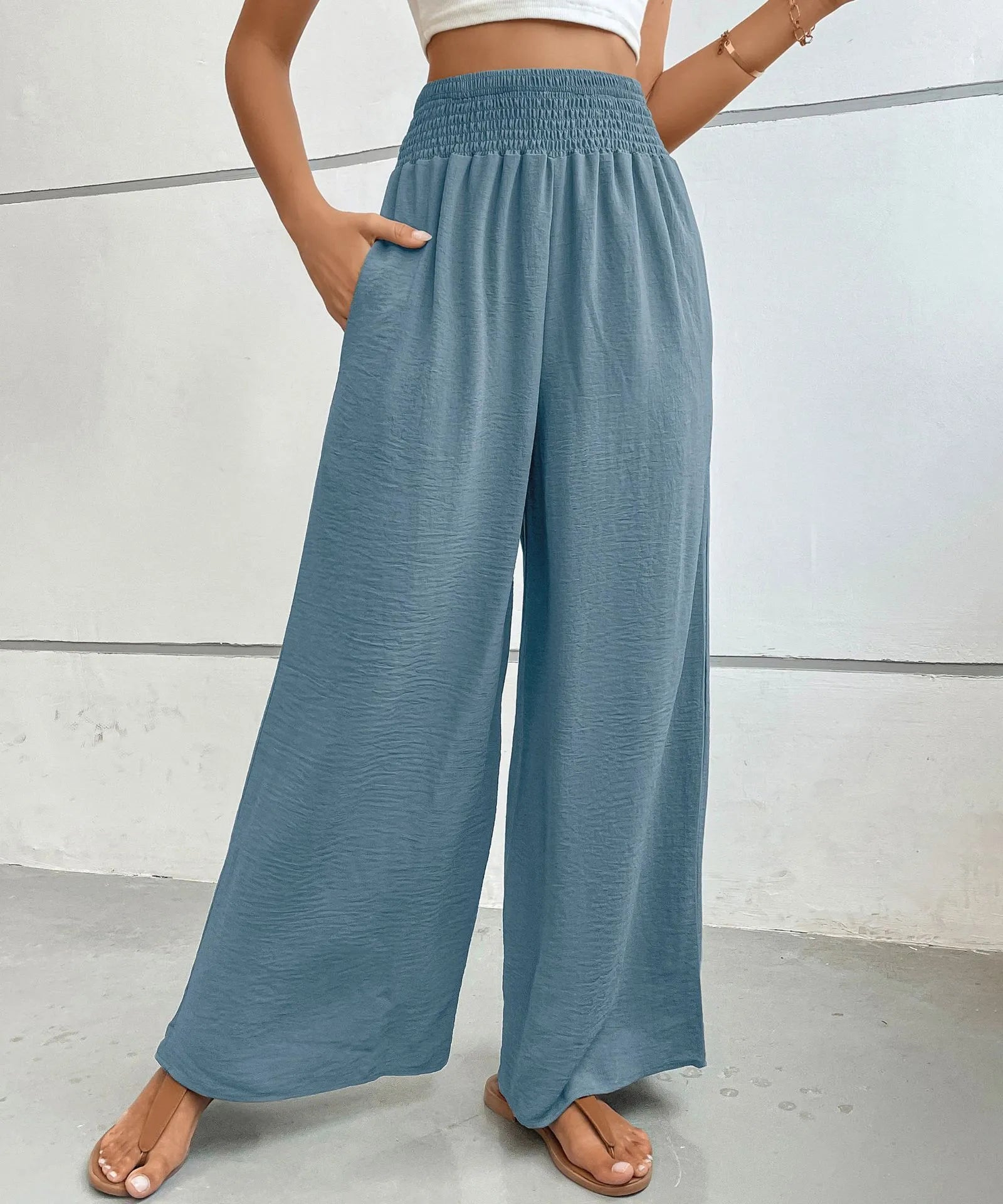 High-waisted wide-leg pants in dusty blue with smocked waist and loose wide pant legs