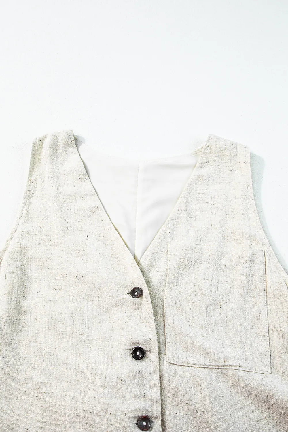 Light beige sleeveless romper front with V-neck, button placket, and chest pocket