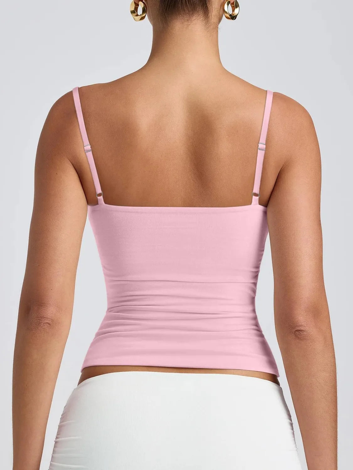Scoop neck cami in blush pink, visible back straps and ruched waist detail.