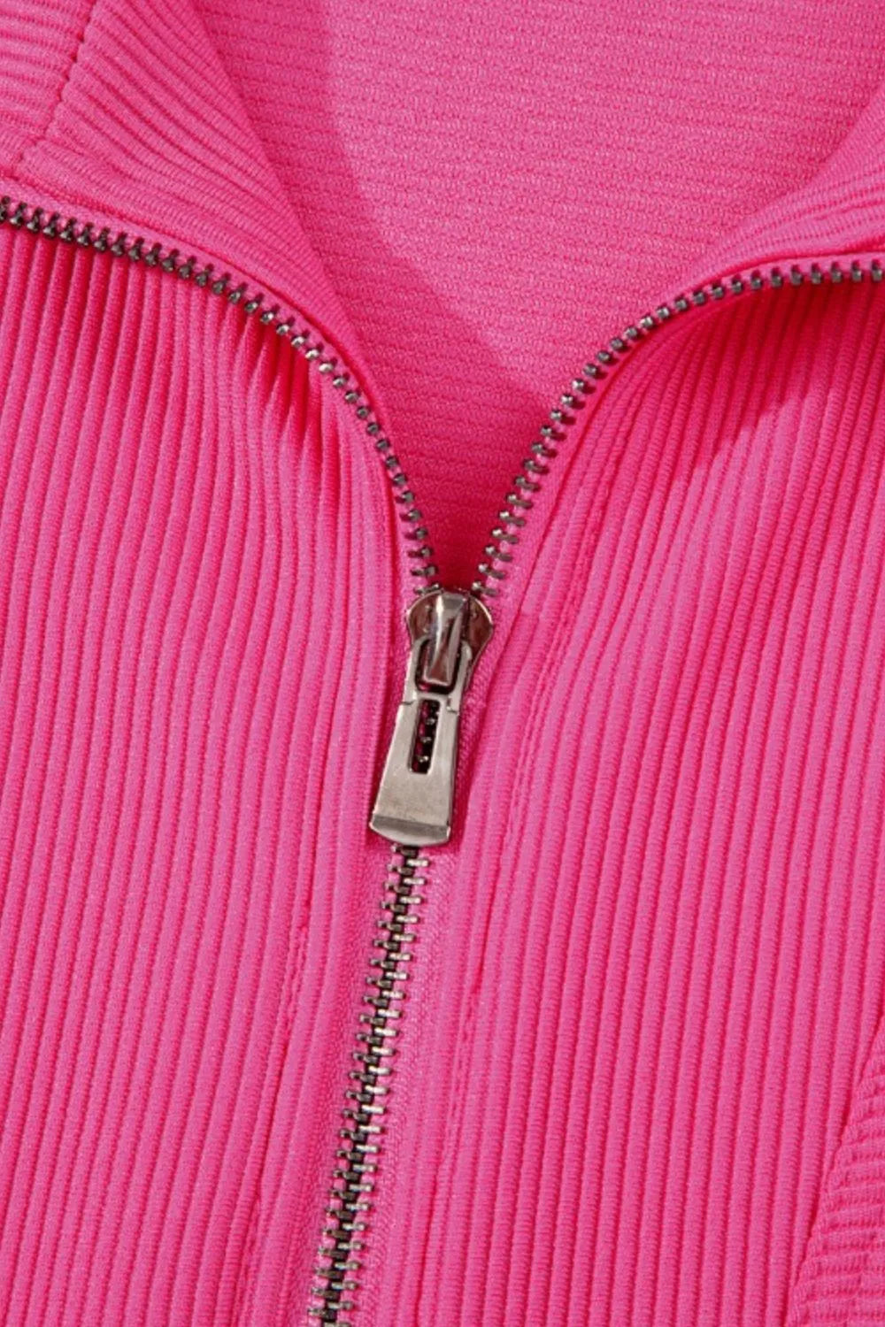 Hot pink textured half-zip front detail with metal zipper and placket teeth