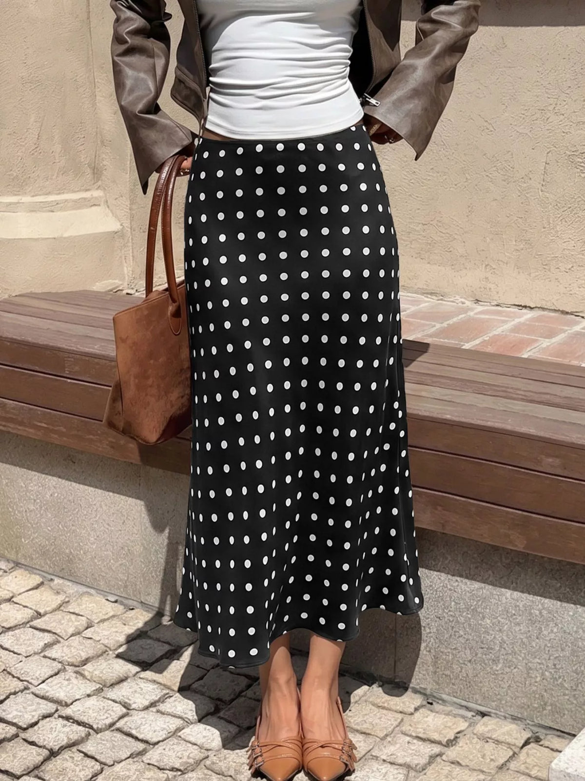 Black polka dot midi skirt with fitted waist and long pleated fall