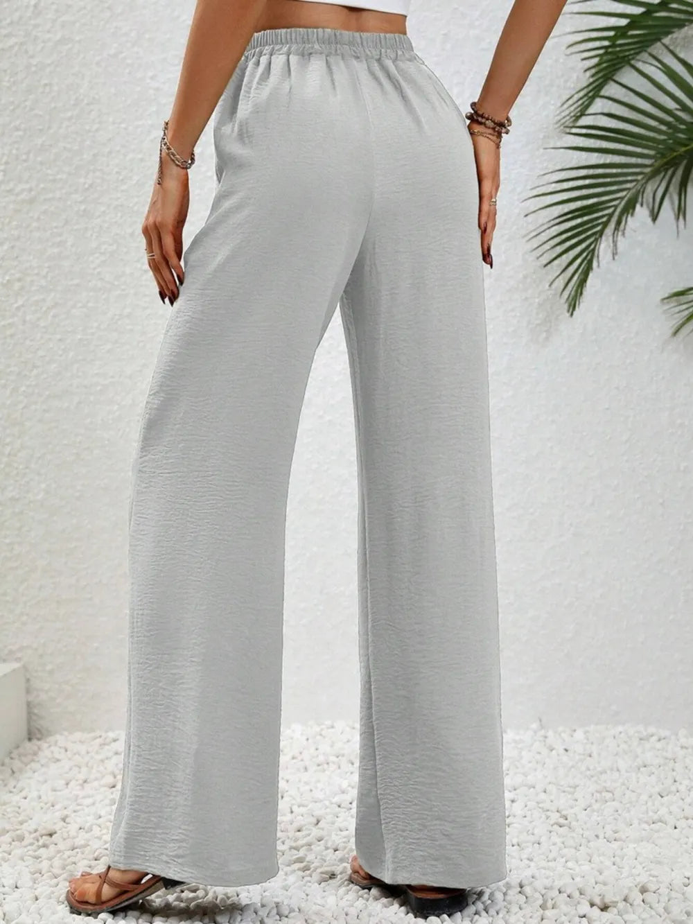 Light gray wide-leg drawstring pants with elastic waistband and wide straight legs