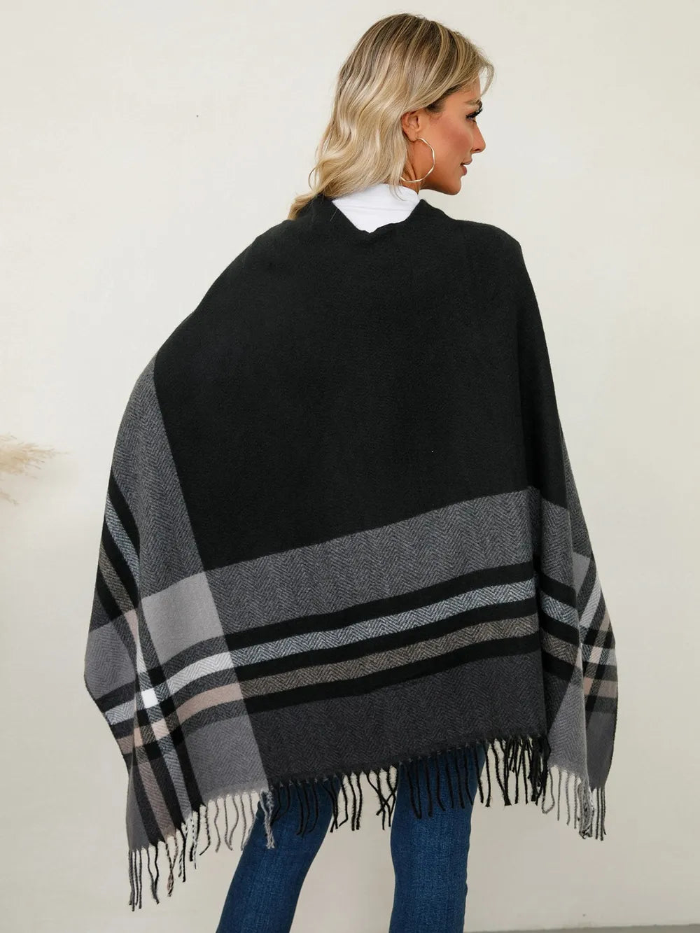 Plaid contrast poncho back view with fringe hem, black and gray striped pattern