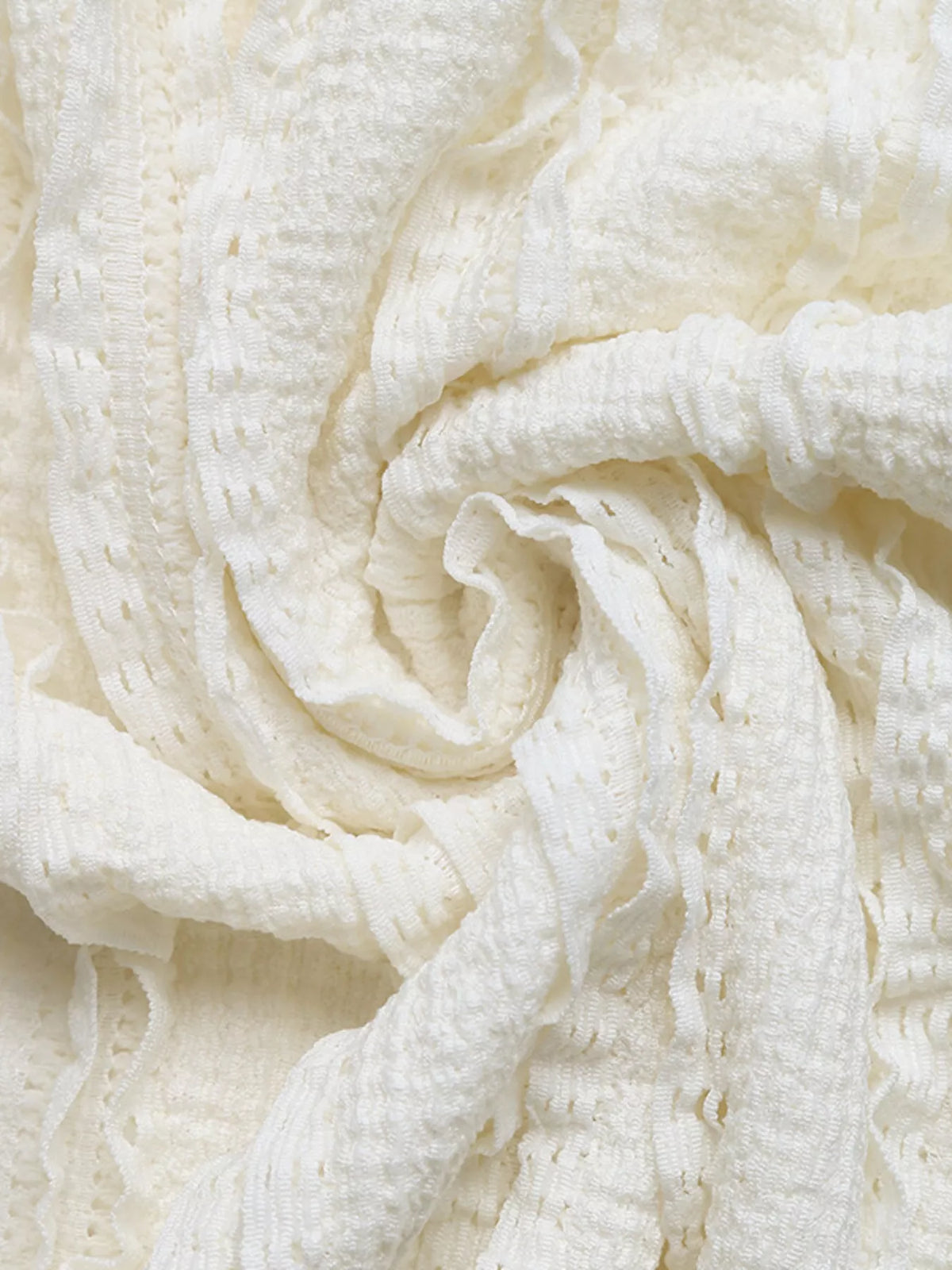 Ivory soft textured fabric close-up with gathered stitching and scalloped texture