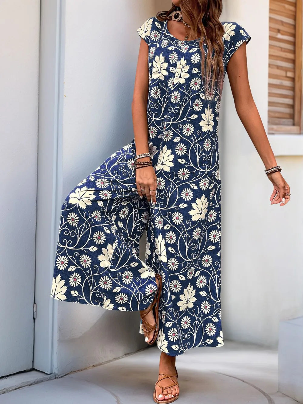 Navy printed wide-leg jumpsuit with round neck and cap sleeves, front view with bag