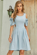 Light blue cold-shoulder dress with tied cutout sleeves and pleated skirt