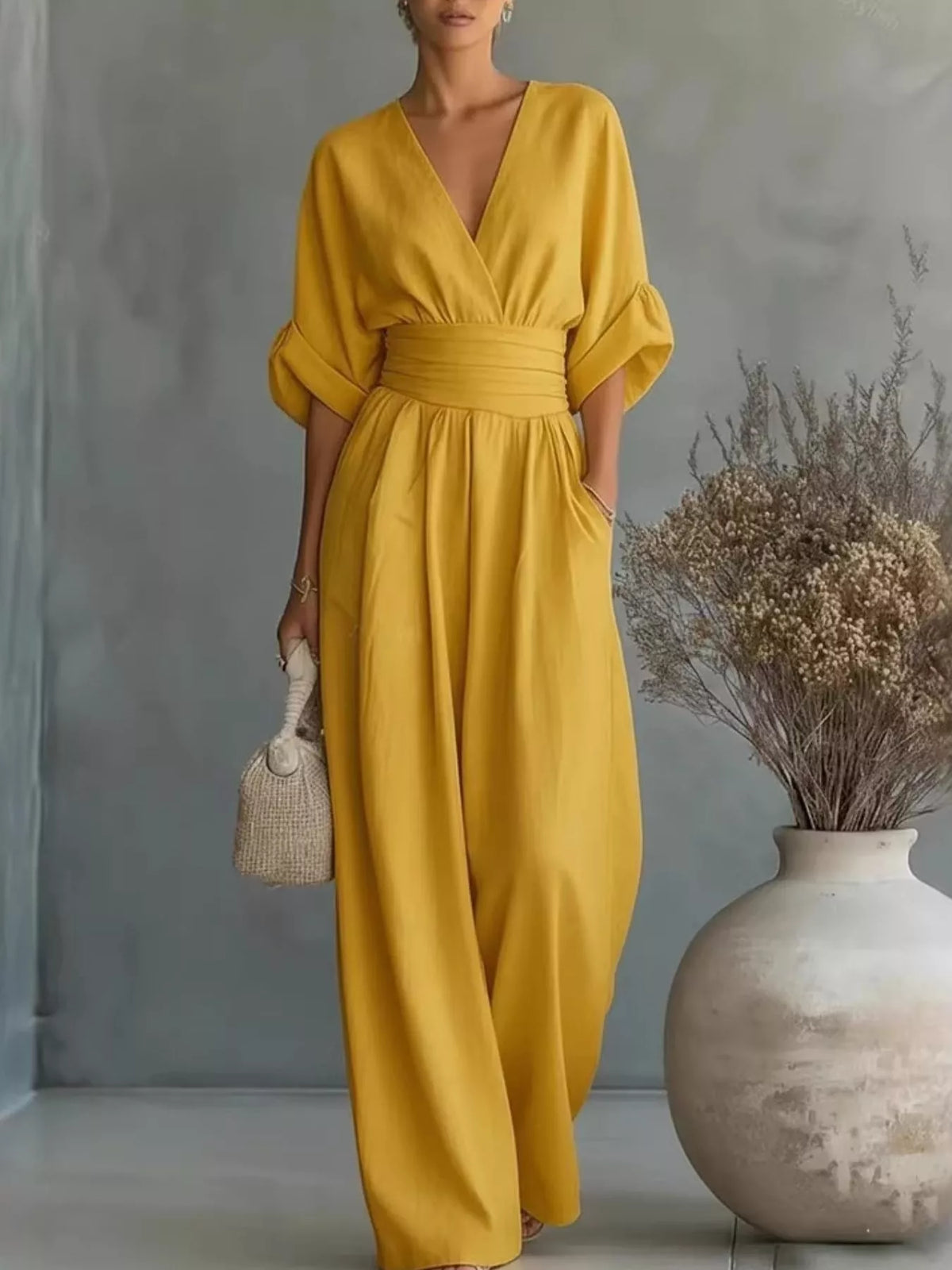 Yellow V-neck wide-leg jumpsuit with ruched waist and half sleeves.