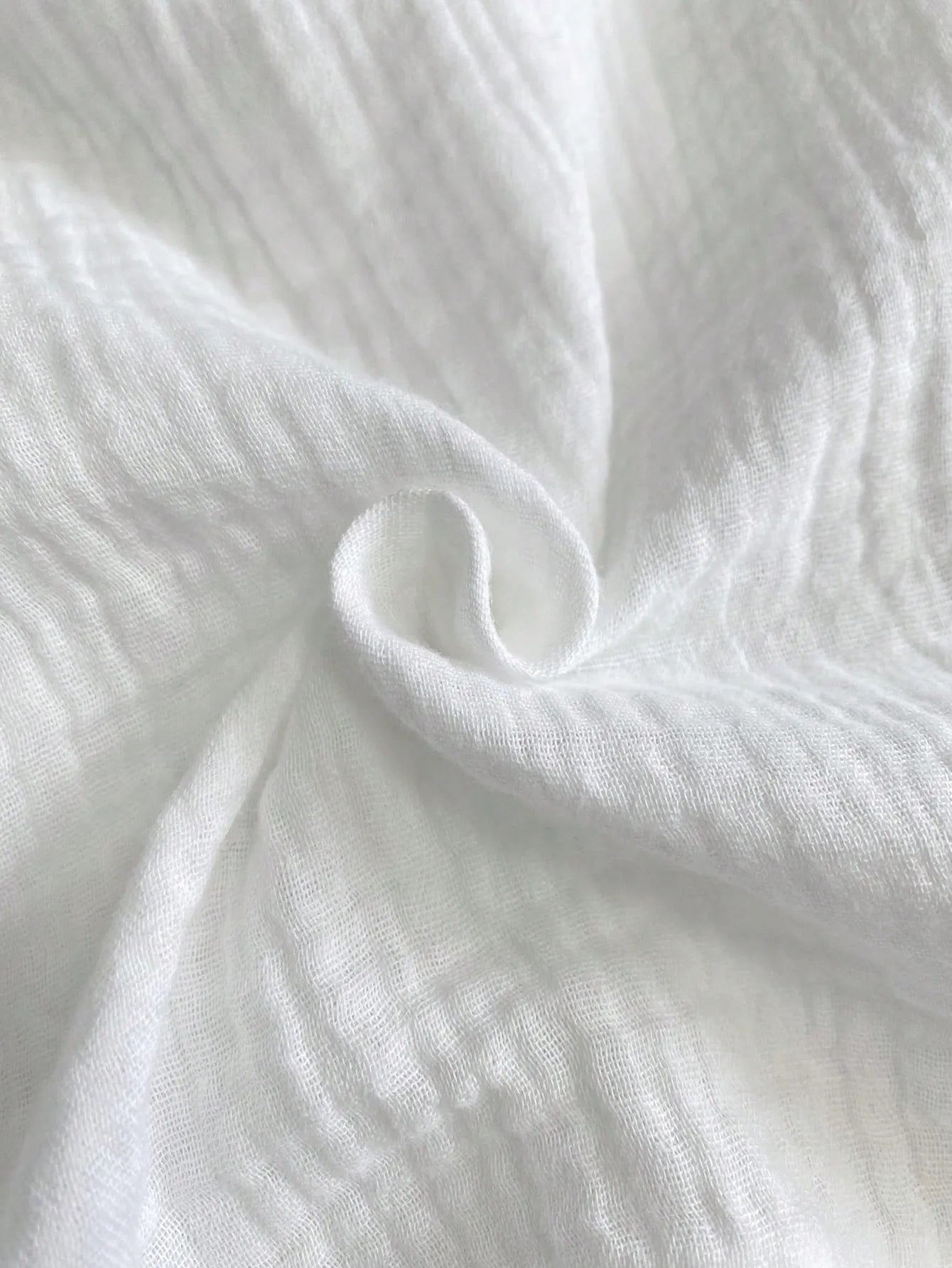 White drawstring tie at elastic waist, close-up on wide-leg pants.