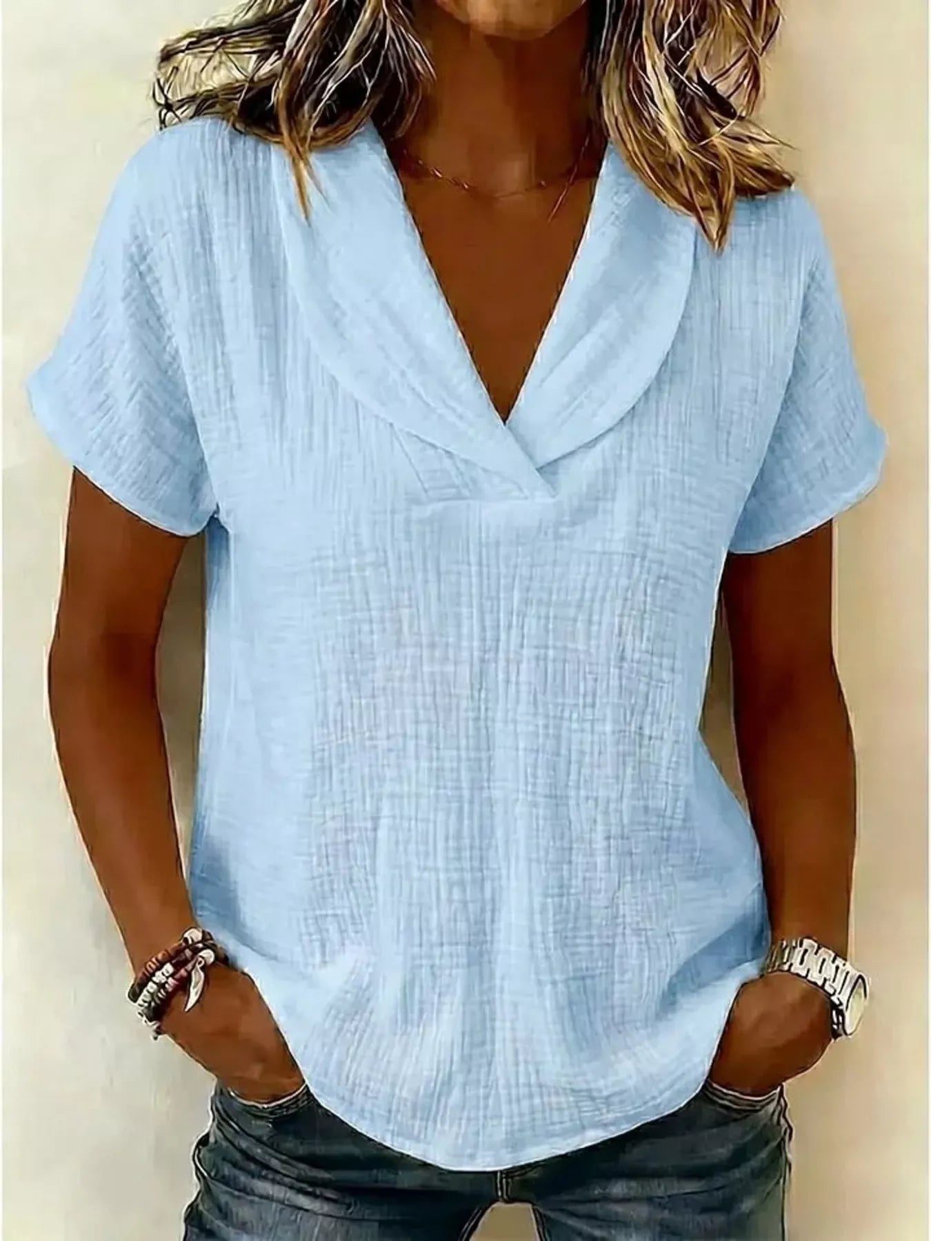 Light blue textured short-sleeve blouse with V-neck and smooth drape
