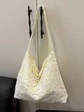 White lace shoulder bag with long loop handles and floral openwork design