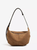 Brown suede crescent shoulder bag with adjustable strap and front zipper detail