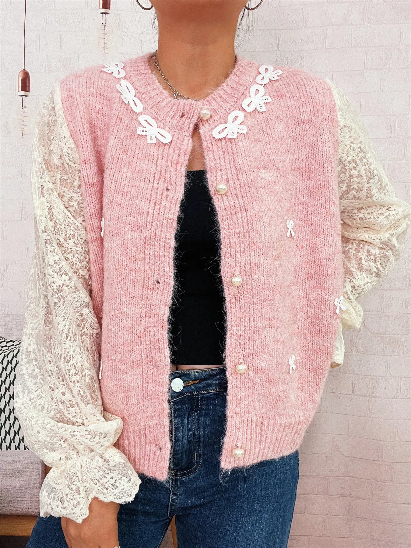 Pink knit button-up cardigan with lace sleeves, open front and bow appliques