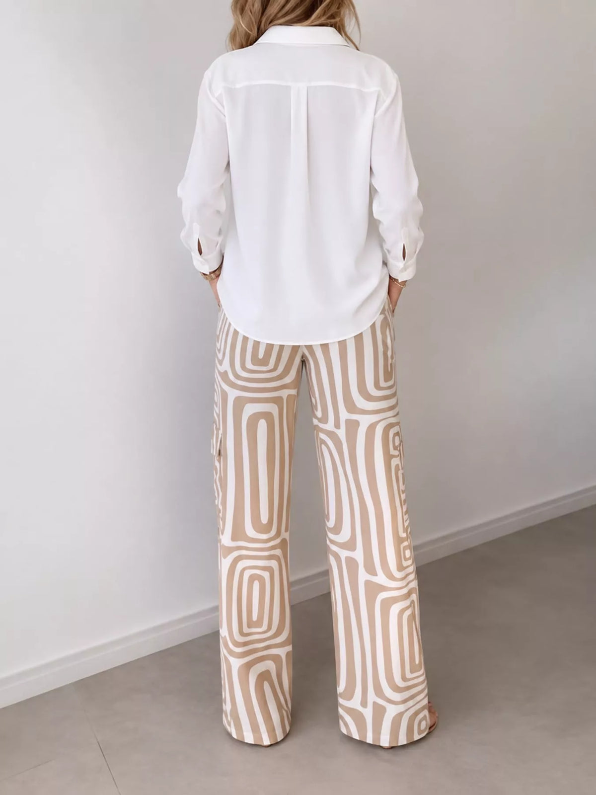 Back view of button-down shirt and geometric patterned pants set in cream and tan.