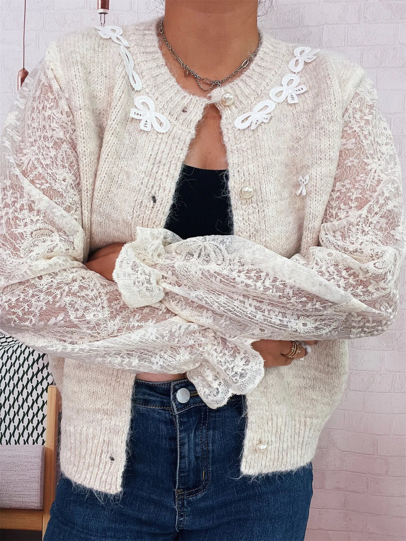Cream lace-sleeve cardigan with front buttons and scalloped lace cuffs