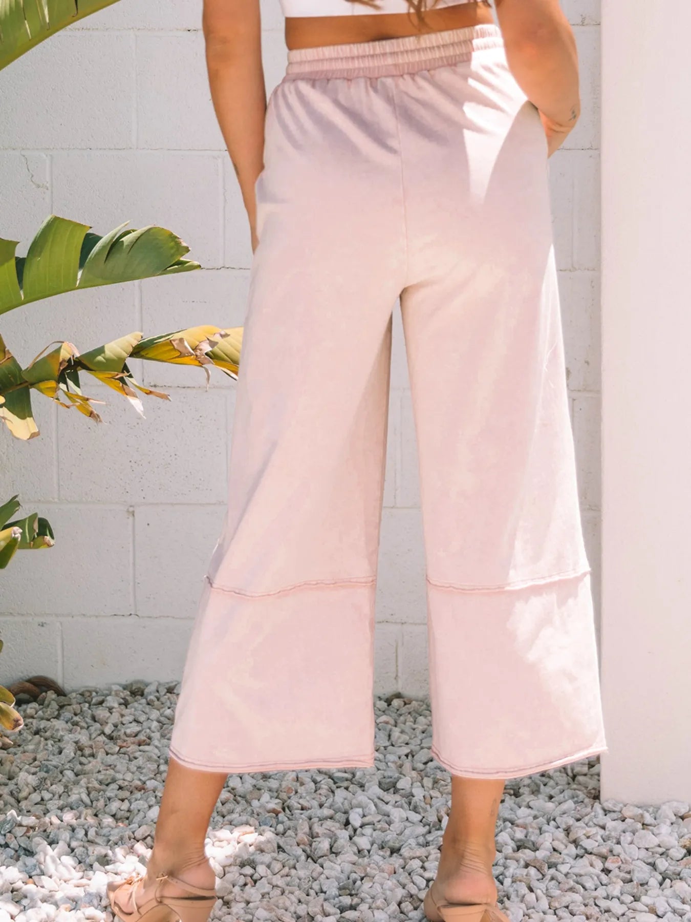 Blush pink wide-leg crop pants with drawstring waist and floral applique-style embroidery