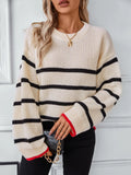 Cream knit sweater with black horizontal stripes, round neck, dropped shoulders, red-trim cuffs