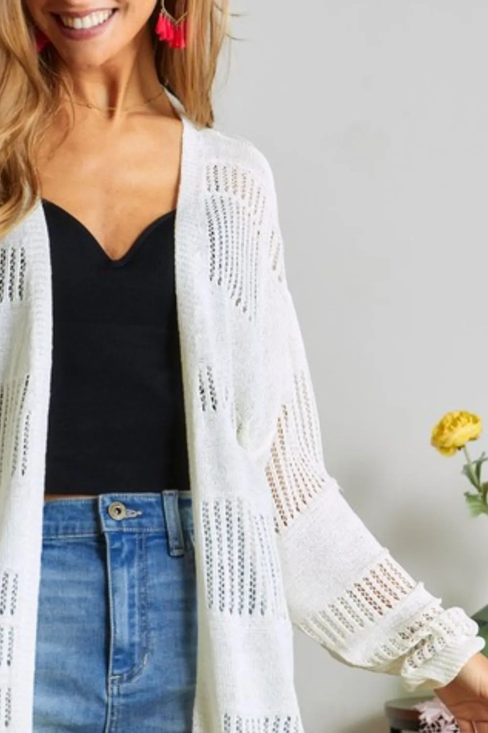 Ivory knit cardigan sleeve and textured panel detail over black camisole