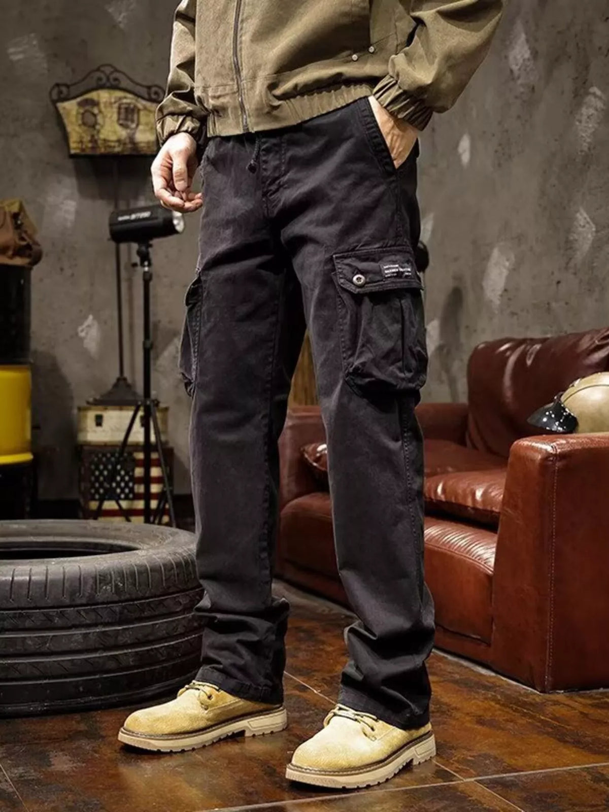Mens multi-pocket drawstring cargo pants in black with flap cargo pockets