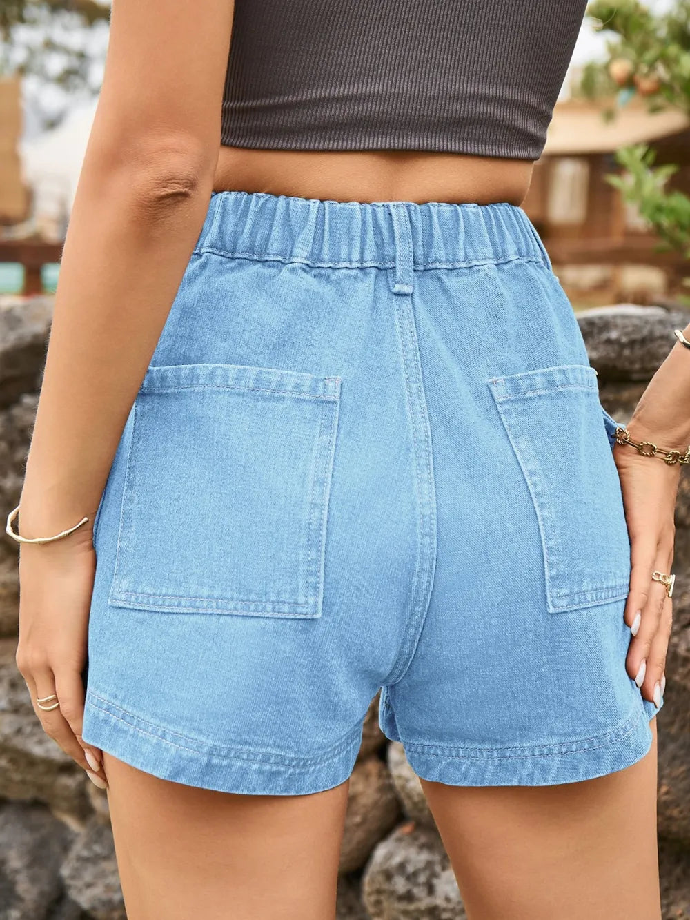 High-waist light blue denim shorts with front button, belt loops, and two cargo-style pockets