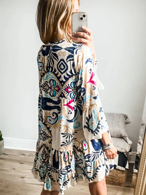 Bohemian print tiered mini dress, back view, white fabric with navy and blue motif