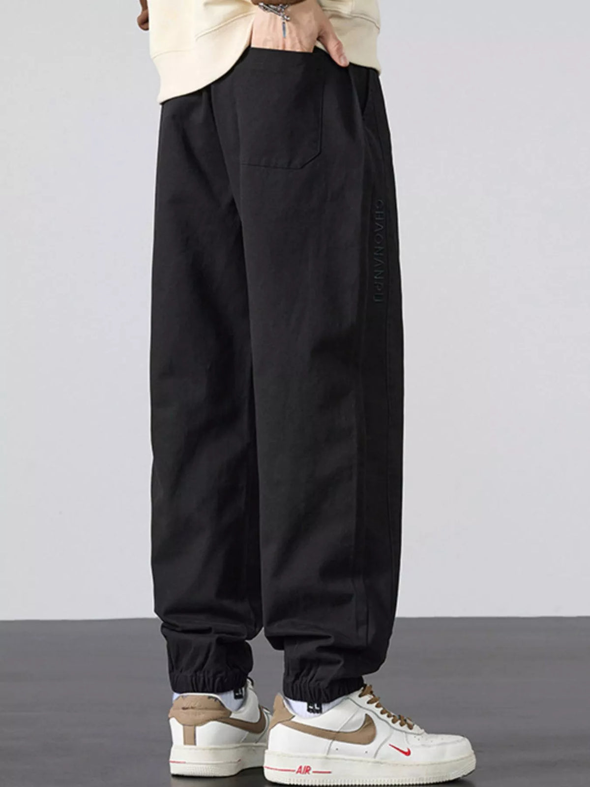 Men's casual loose-fit black jogger pants with side pocket and elastic cuffs