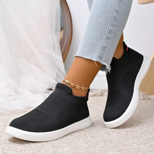 Black knit mesh slip-on athletic sneakers with white sole and red collar accents