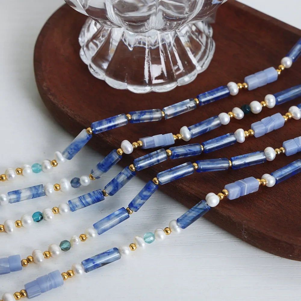 Blue geometric bead necklace with freshwater pearls and gold spacer beads, layered view