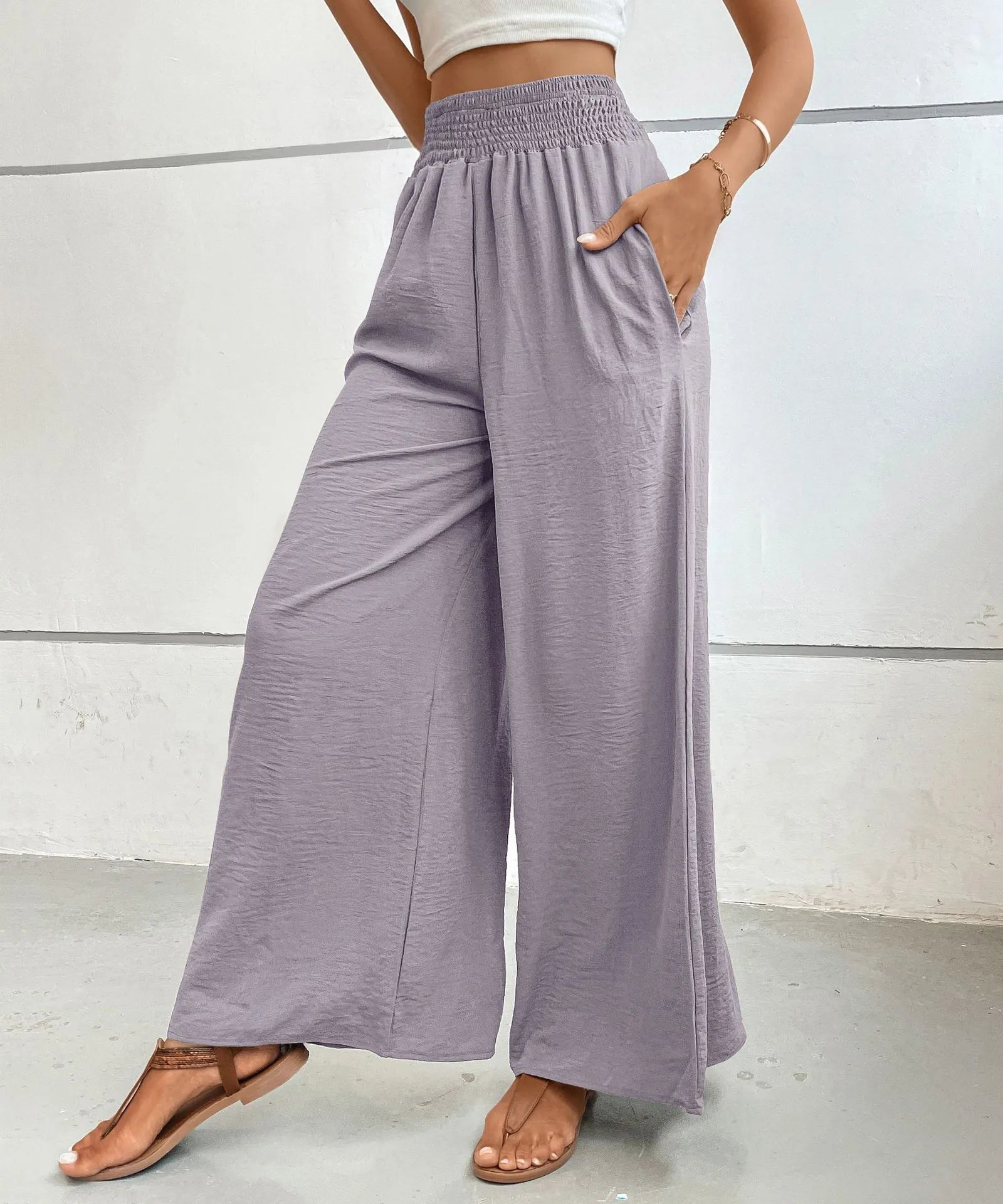 High-waisted wide-leg pants in lilac with elastic smocked waistband and relaxed drape.