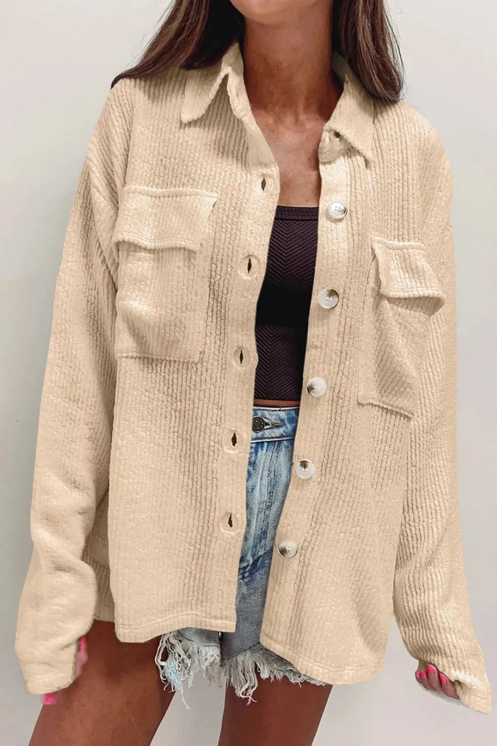 Beige button-up long sleeve shacket with point collar, flap chest pockets, and metal buttons