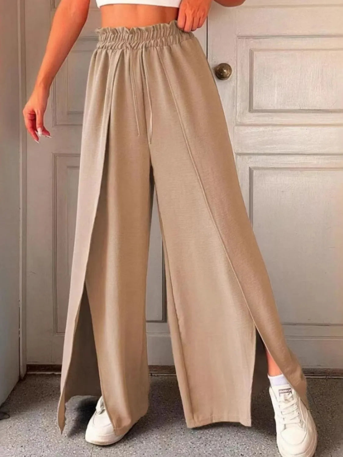 Tan slit wide-leg pants with elastic waistband and drawstring, side slit hem