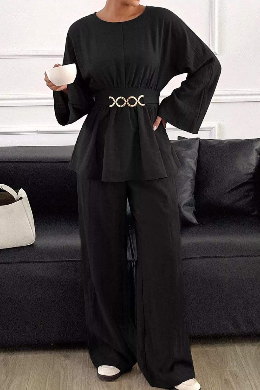 Black peplum top and wide-leg pants set with metal ring waist detail.
