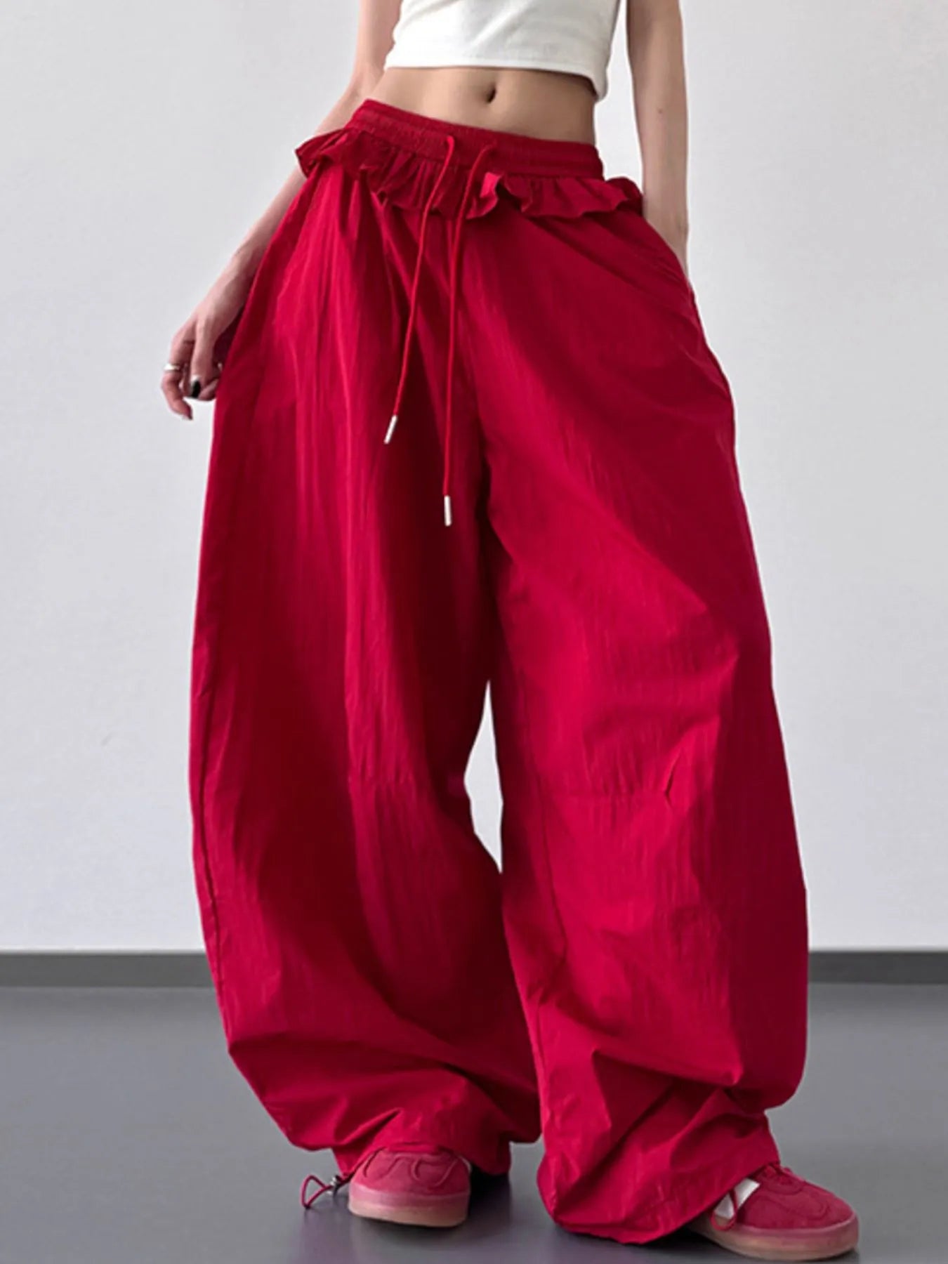 Red drawstring wide-leg pants with ruffled waistband and loose, billowy legs