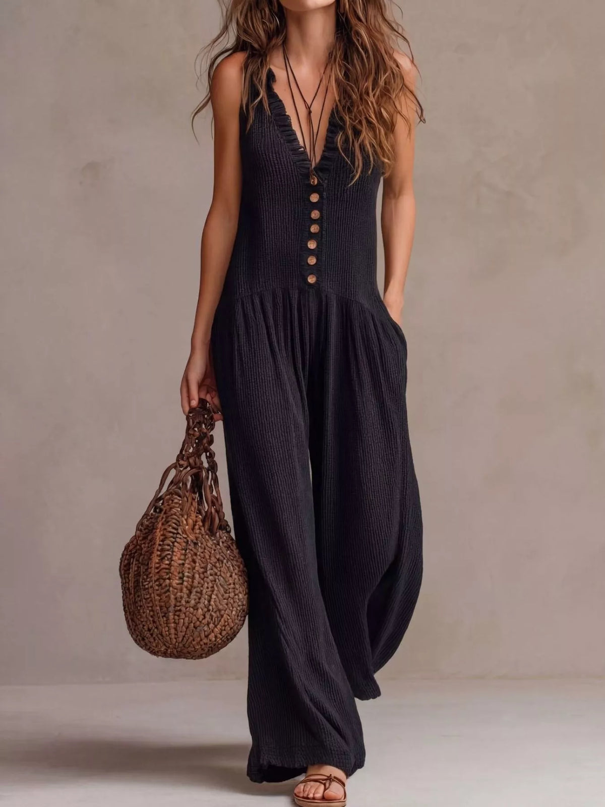 Dark navy sleeveless V-neck jumpsuit with front buttons and loose wide-leg fit