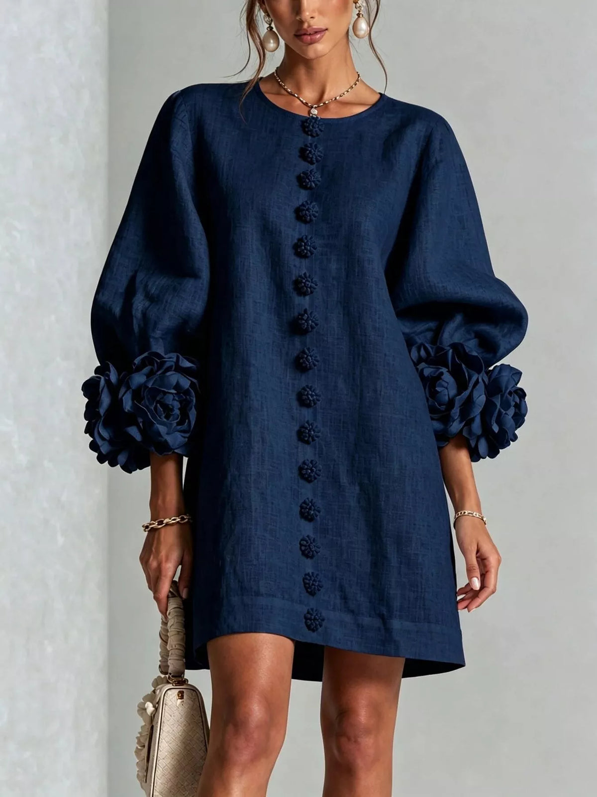 Navy mini dress with round neck, vertical button trim, and 3D floral puff sleeves.