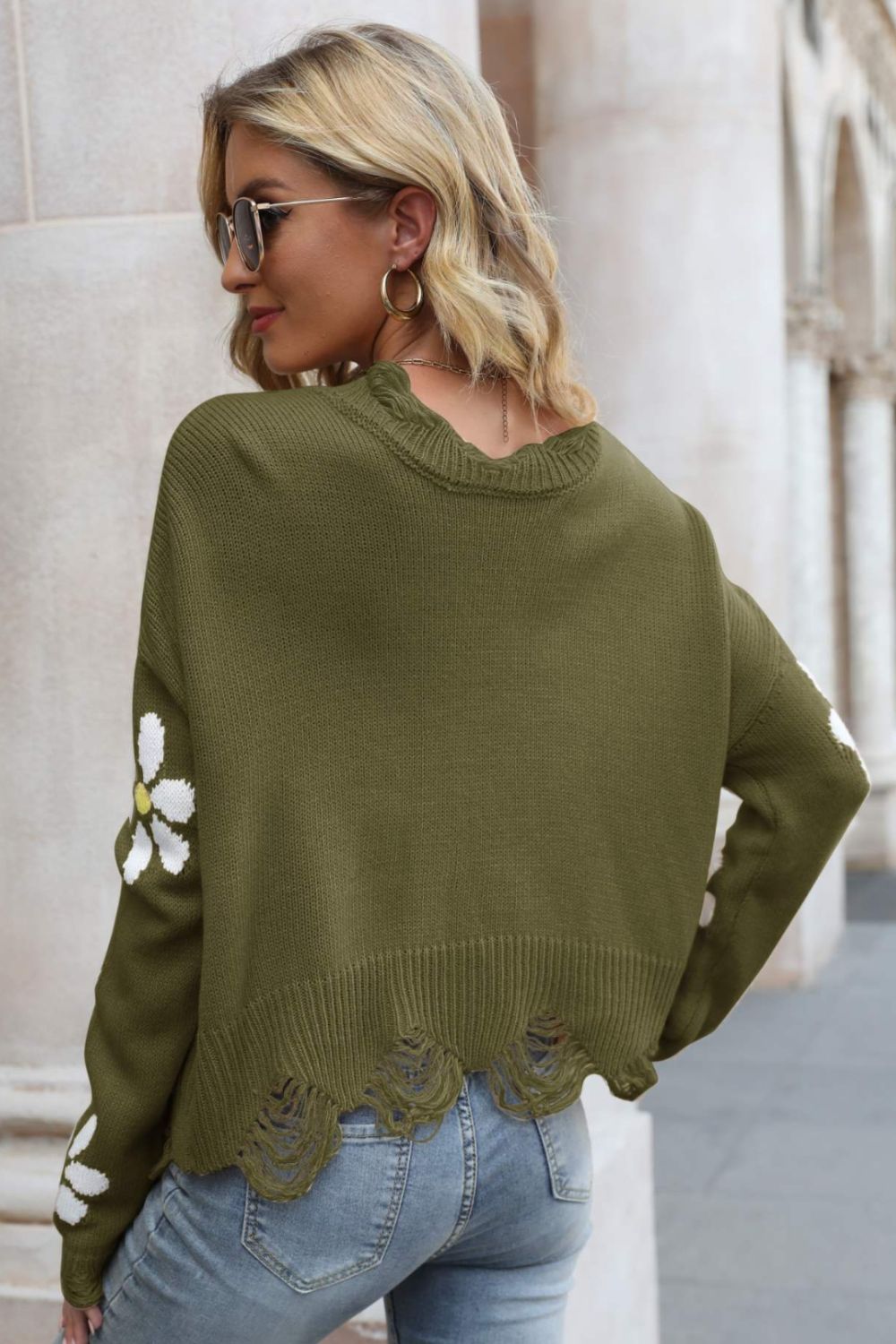 Olive green distressed ribbed-trim sweater with white daisy details and frayed hem