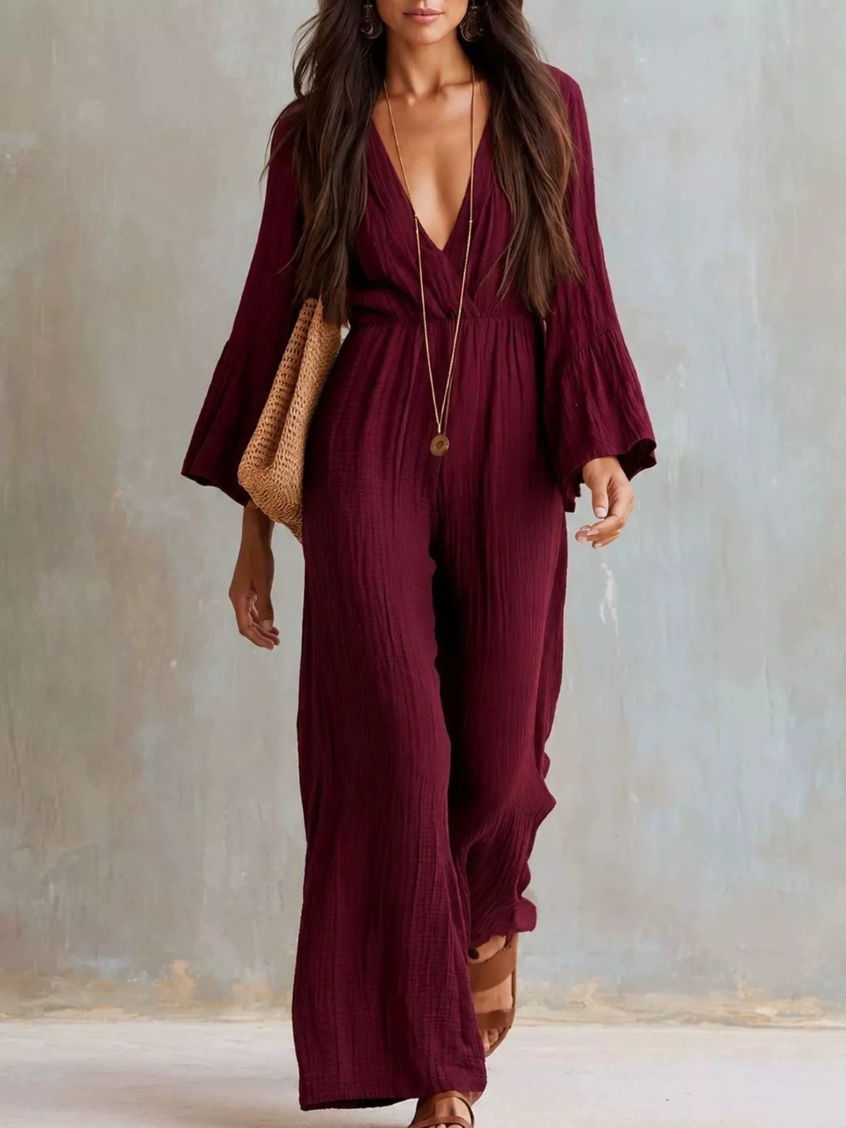Burgundy textured flare-sleeve jumpsuit with deep V-neck and flowing wide legs