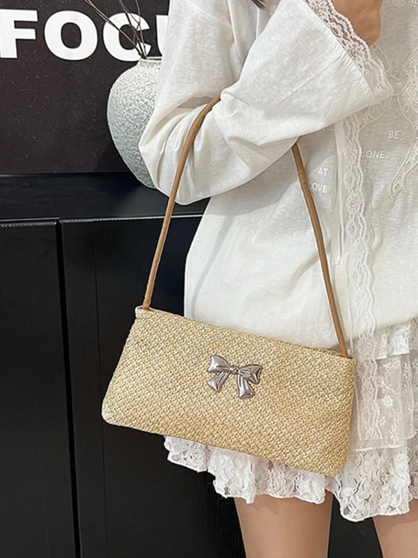 Woven straw shoulder bag with silver bow detail and tan crossbody strap