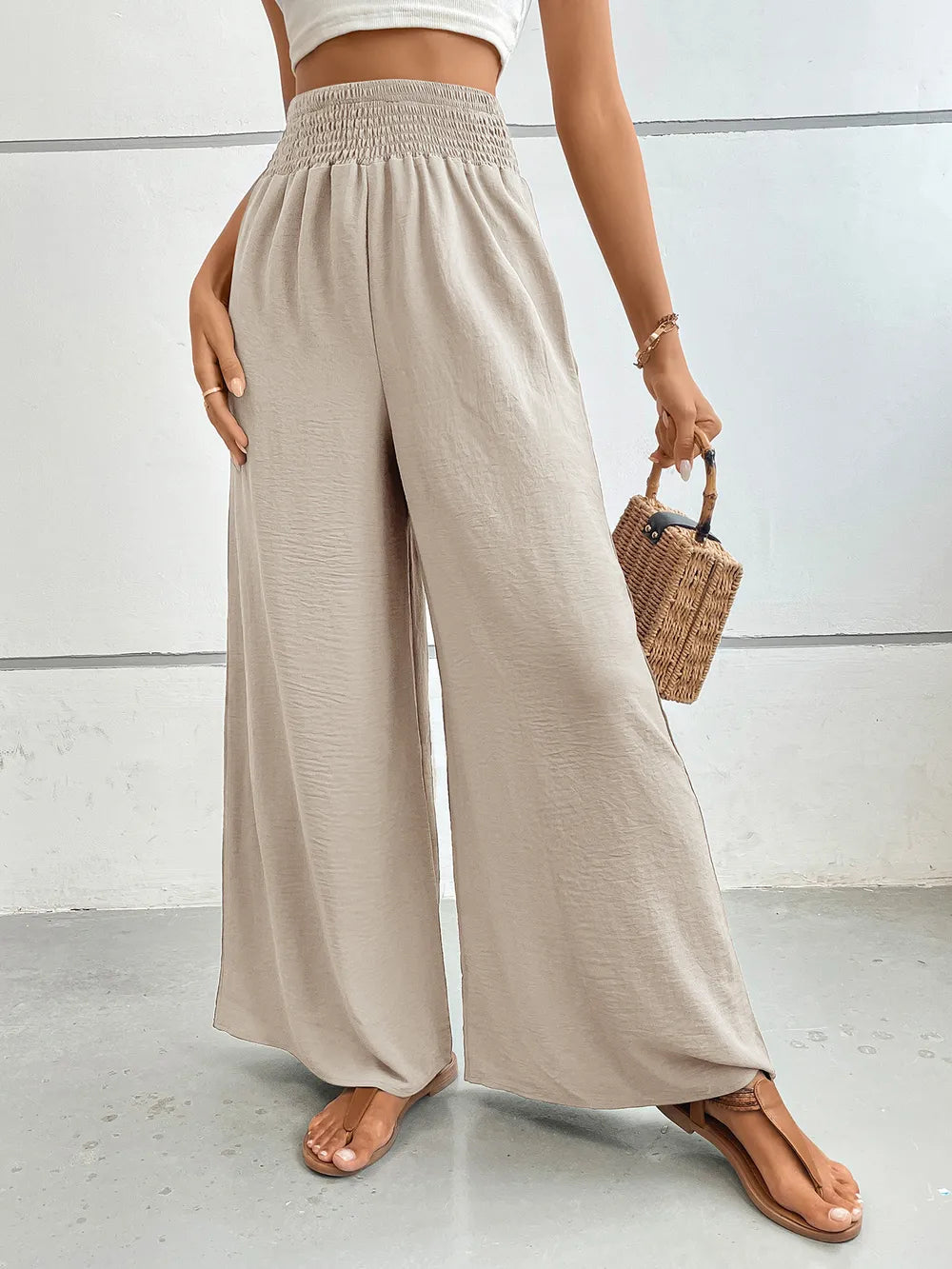 Wide-leg pants with pockets, light beige textured fabric, relaxed wide-leg silhouette.
