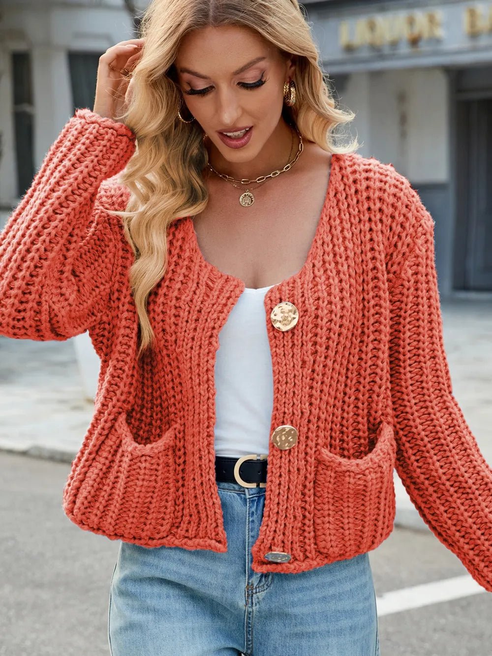 Coral orange round-neck button-up cardigan with button placket and front pockets