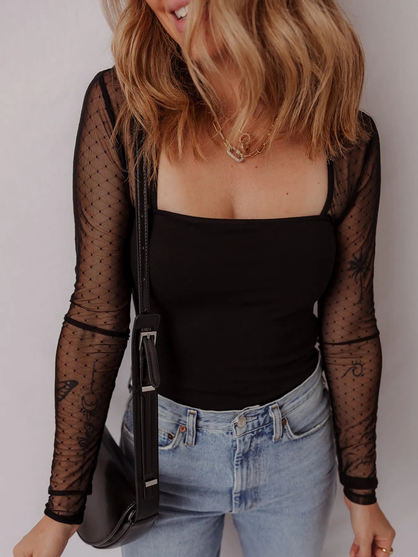 Black mesh sleeve square-neck bodysuit with sheer dotted sleeves and smooth fitted front
