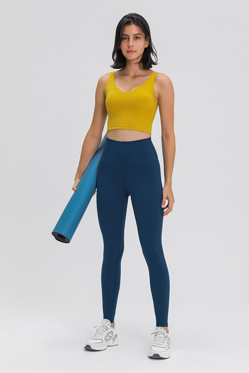 Mustard yellow scoop-back sports bra with wide straps and fitted cropped design
