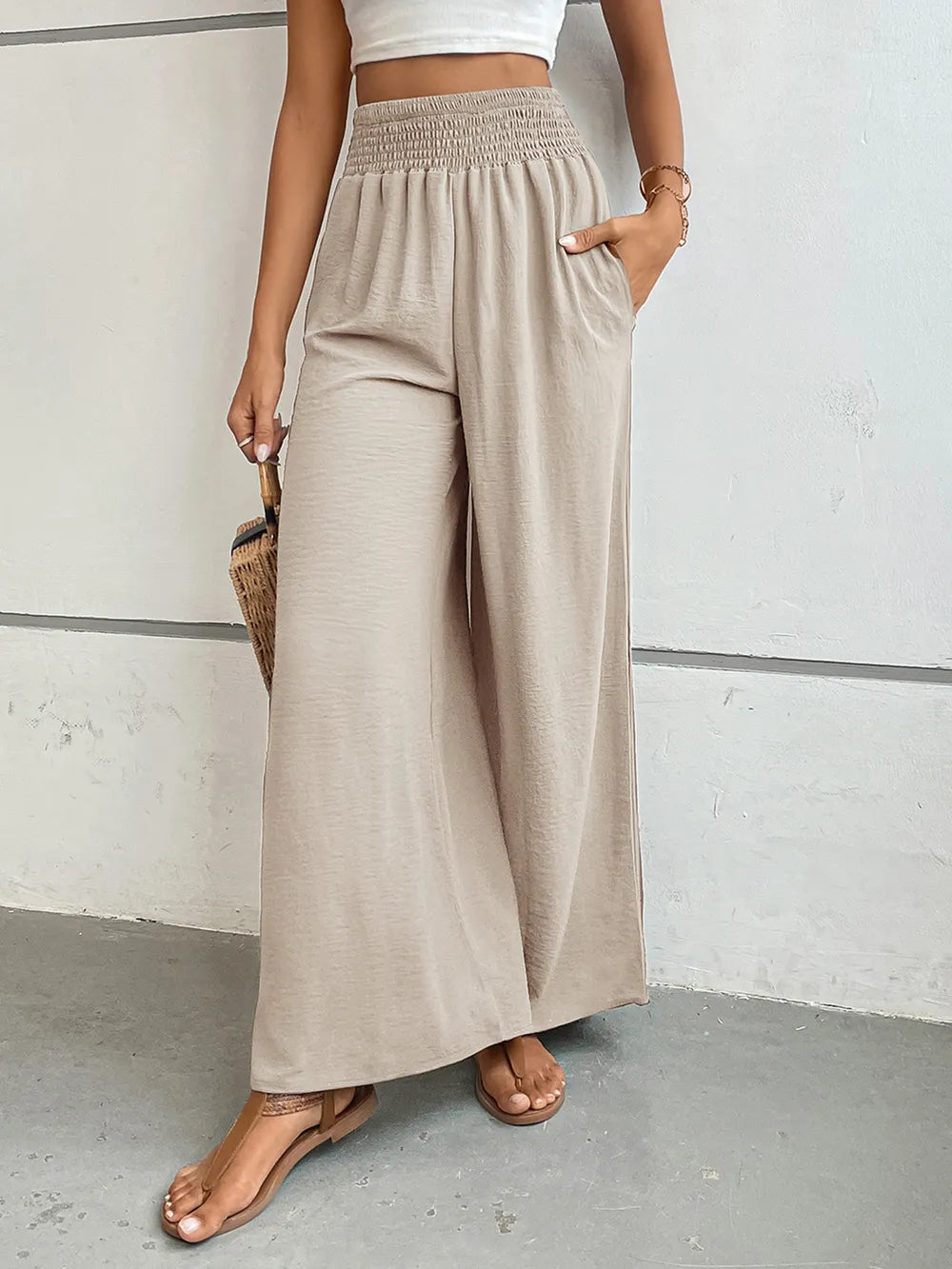 Wide-leg pants with pockets, light beige textured fabric, elastic waist with gathers.