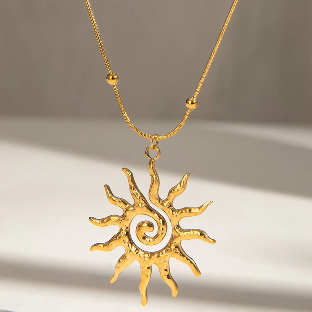 Gold-plated sun pendant necklace with large sun charm and rounded bead chain