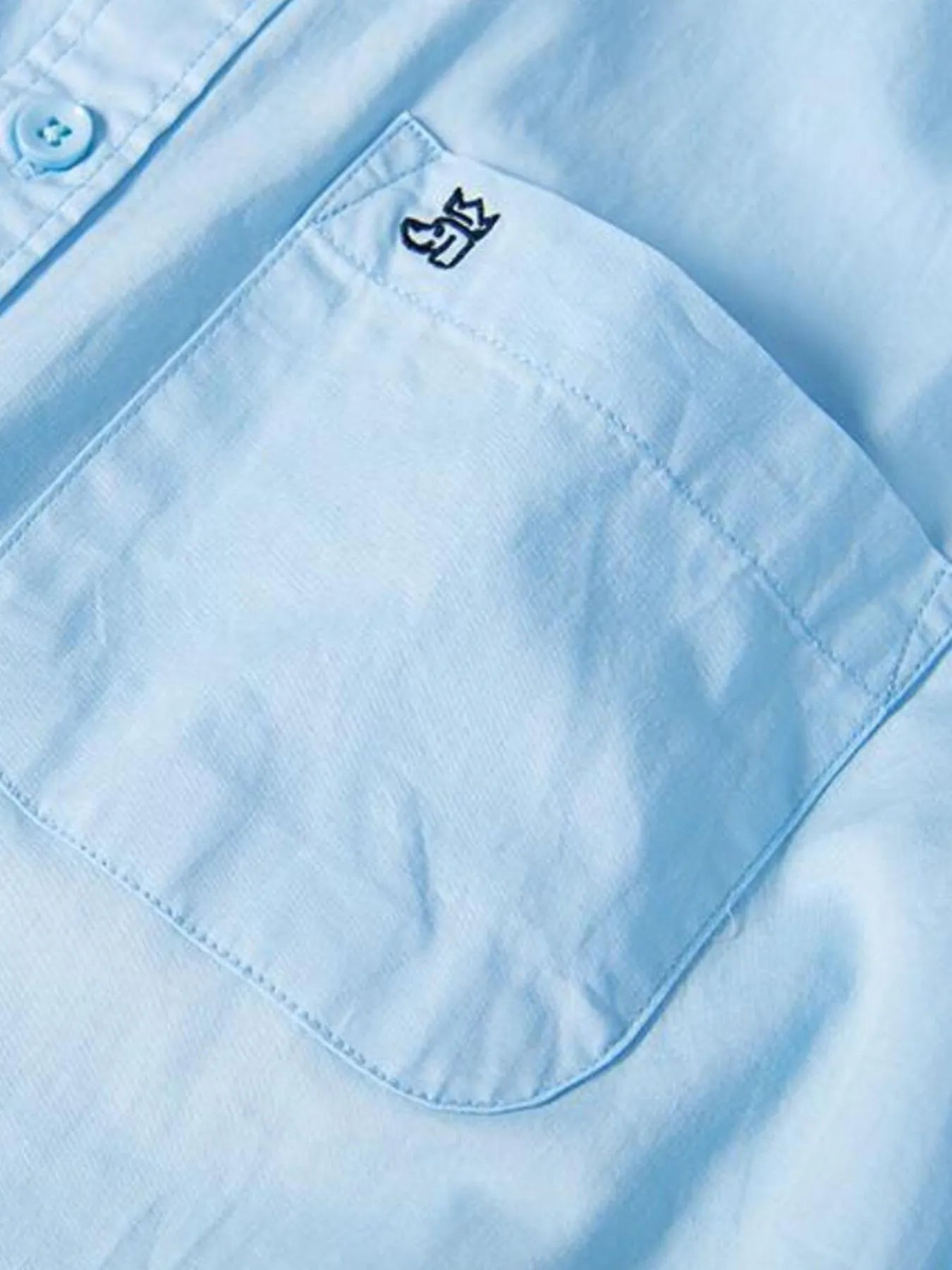 Light blue chest pocket on button-up shirt with small logo patch