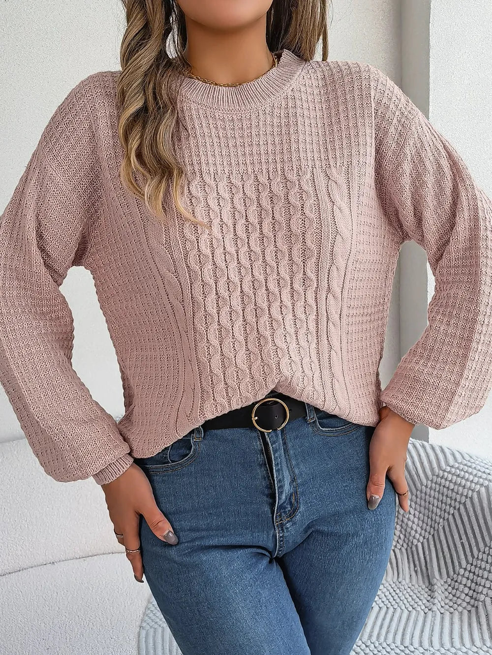Blush cable-knit round-neck sweater with long sleeves and raised cable knit detail.