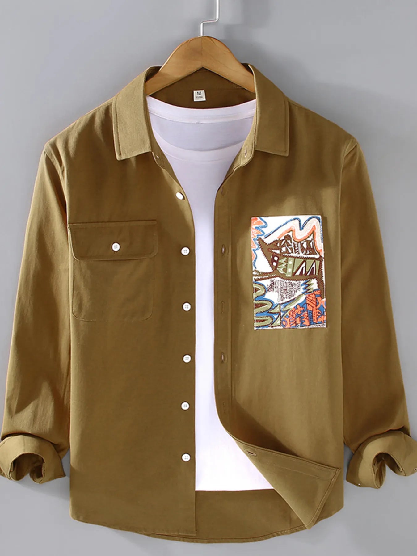 Brown button-up long sleeve shirt with chest pocket, front buttons, graphic patch on chest