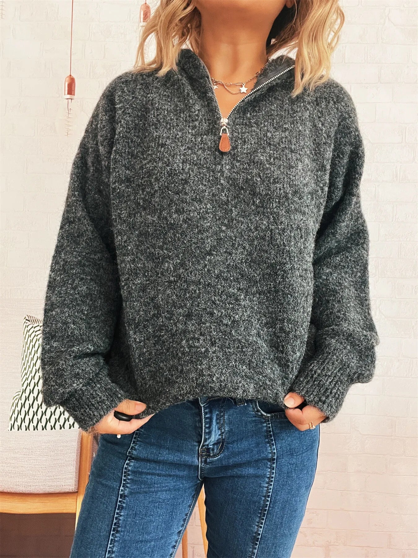 Dark gray quarter-zip knit sweater with ribbed hem and snap-look zipper pull