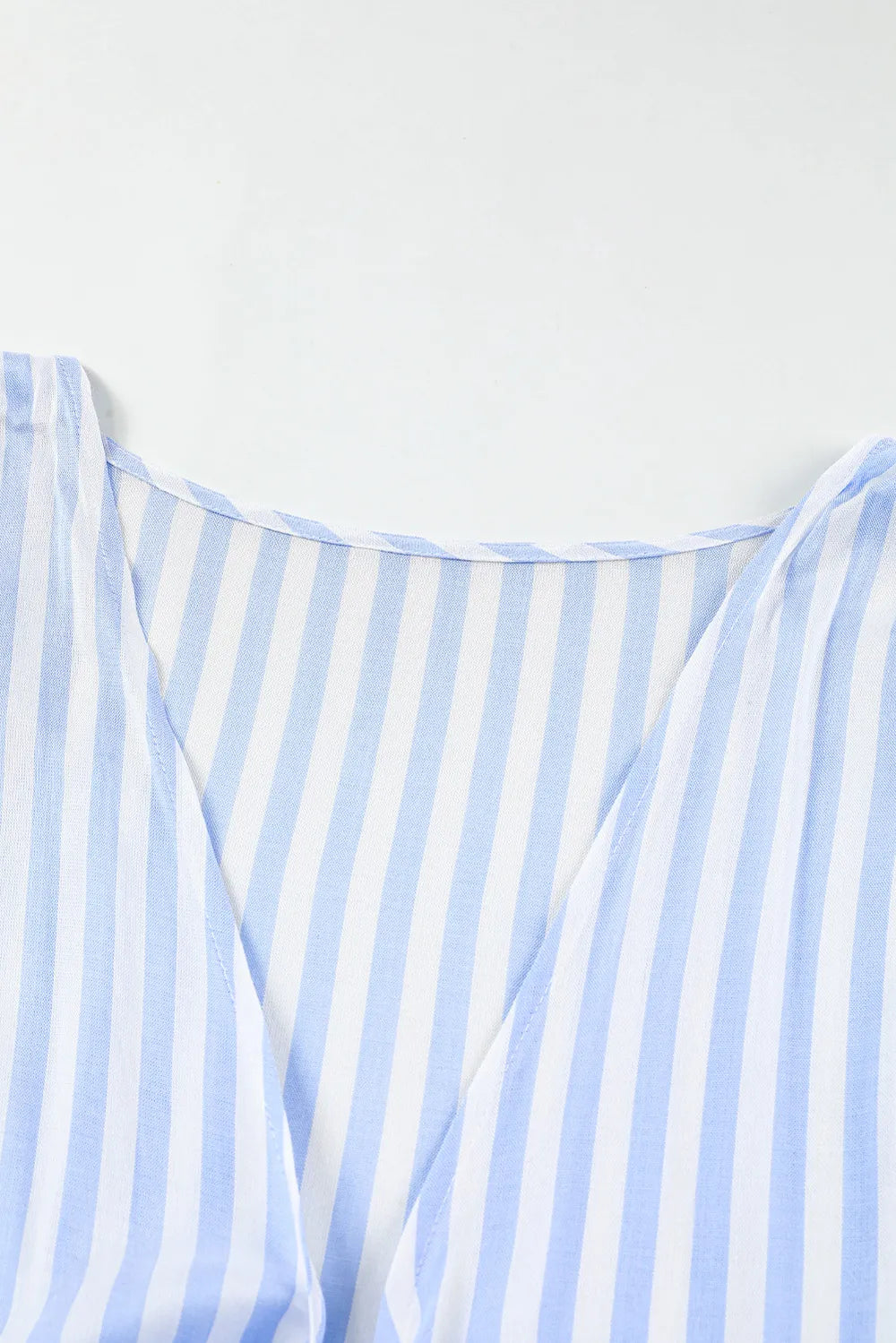 Striped kimono-sleeve romper neckline with V opening and bow-tie details, light blue